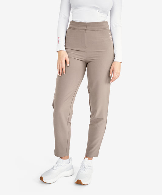 Model wearing mocha brown trousers with white trainers