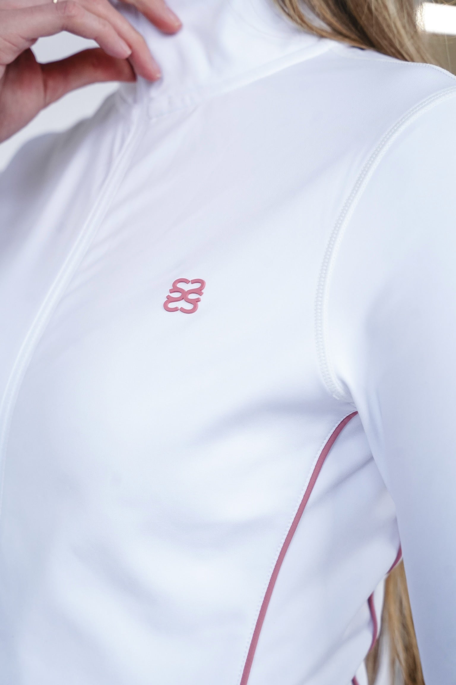 White zip through sports jacket with pink piping and branding