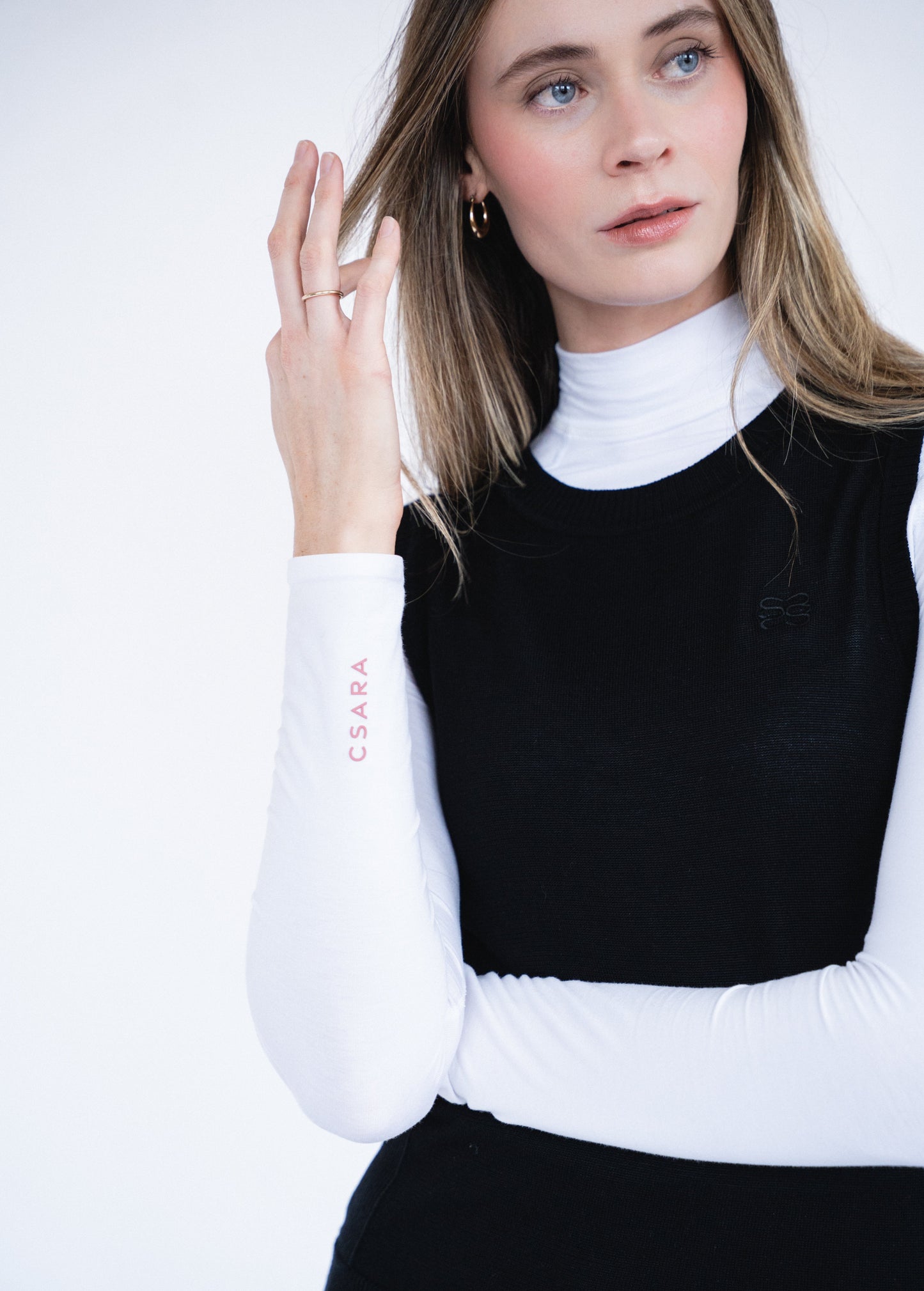 CSARA Raven knitted vest in black, close-up detail of knit texture and embroidered CSARA branding.